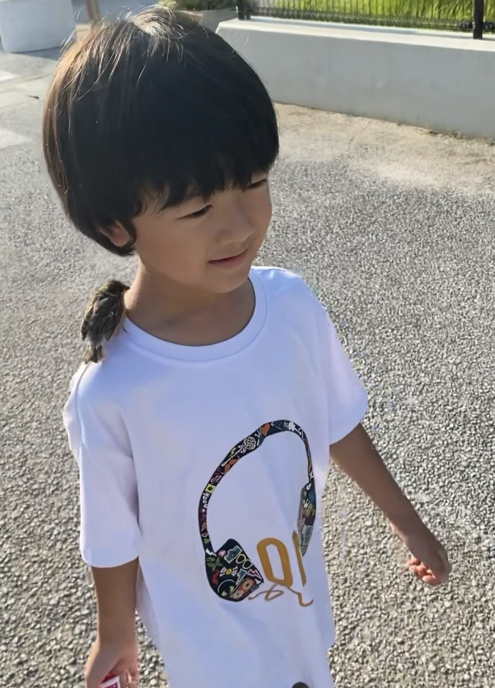 肩に小鳥をとまらせて笑うこども